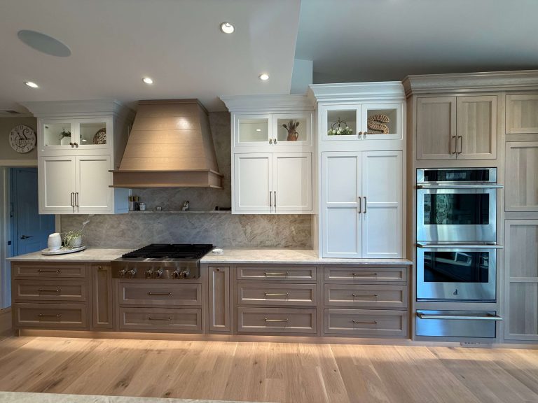 Two-tone kitchen cabinetry with custom wood hood and quartzite backsplash by South Jersey contractor