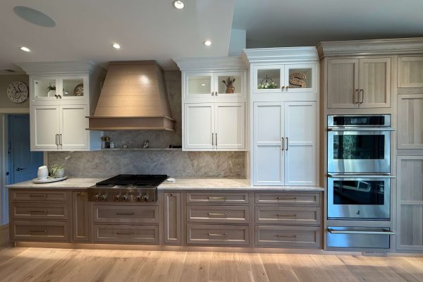 Two-tone kitchen cabinetry with custom wood hood and quartzite backsplash by South Jersey contractor